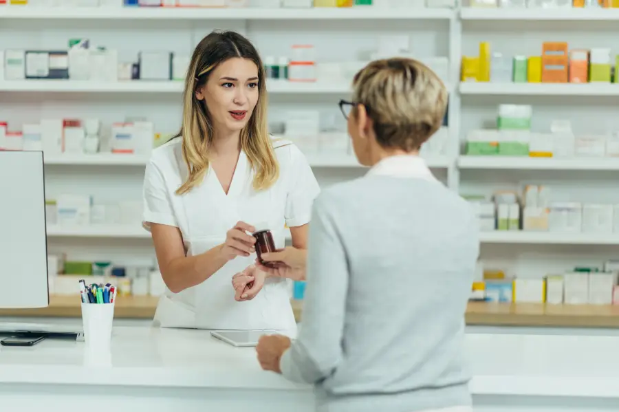 Farmaceutica-que-vende-medicamentos-en-una-farmacia-a-una-clienta